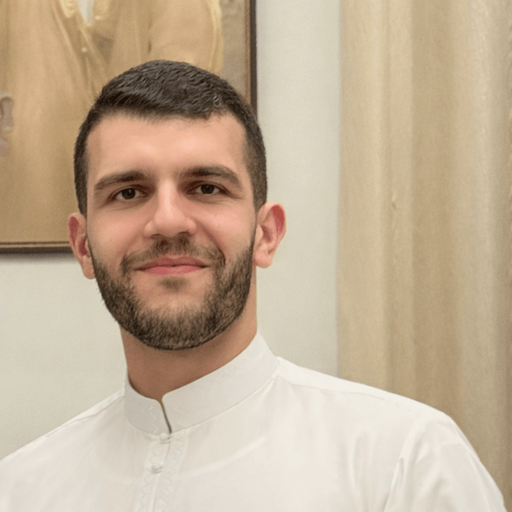 A portrait of me with a short beard wearing a traditional white thobe.